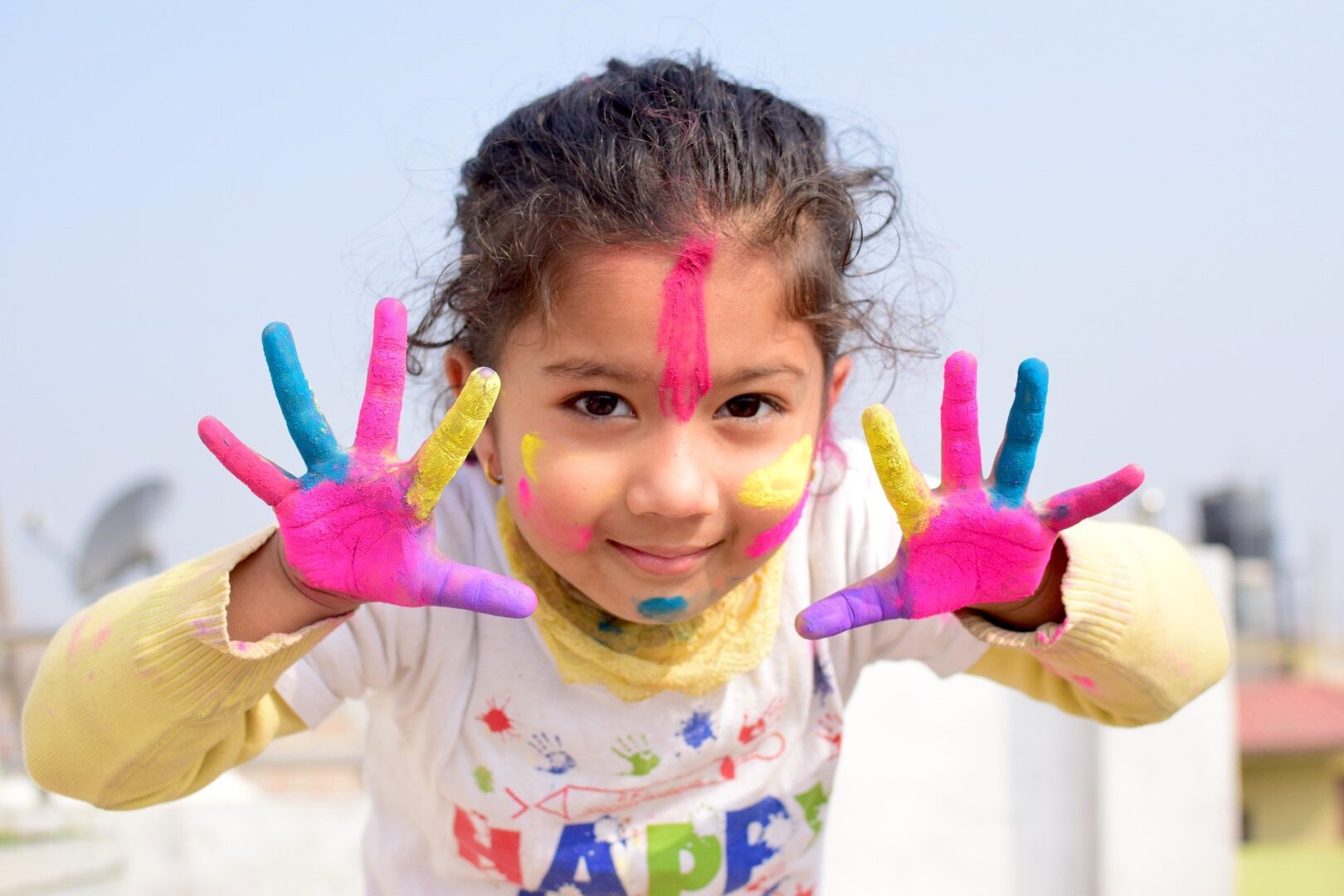 Child with paint on outspread fingers