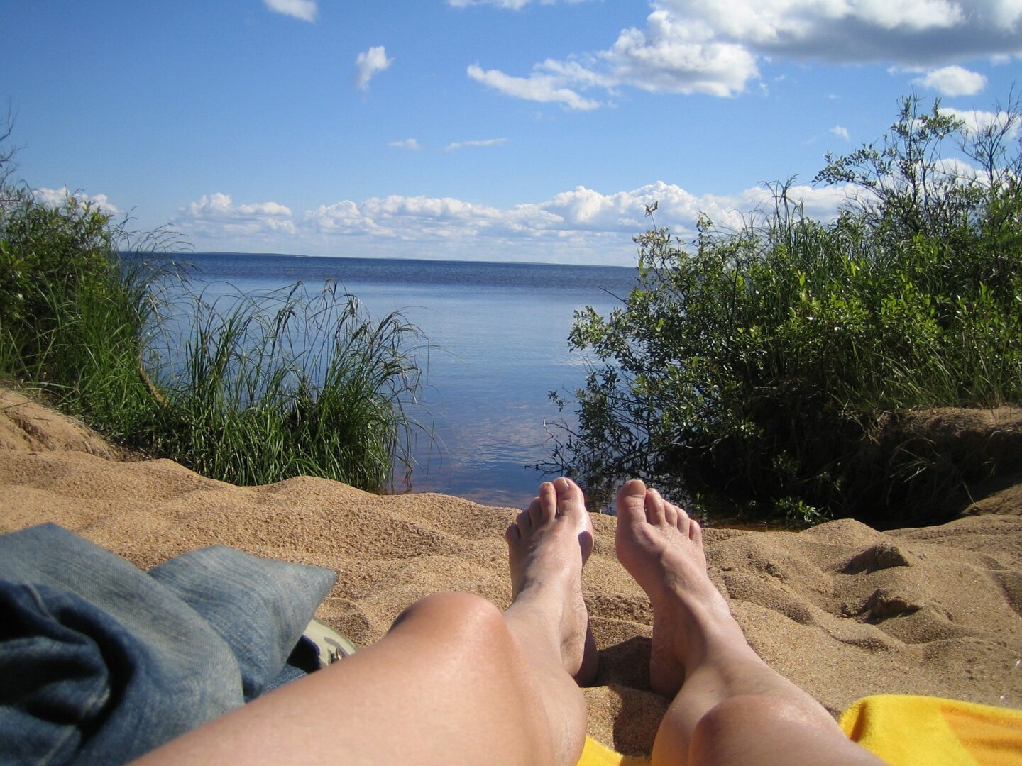 Man with feet looking over a lake
