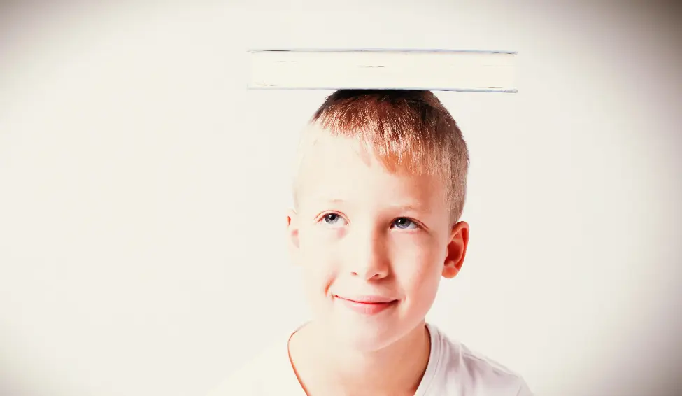 Boy with book on his head