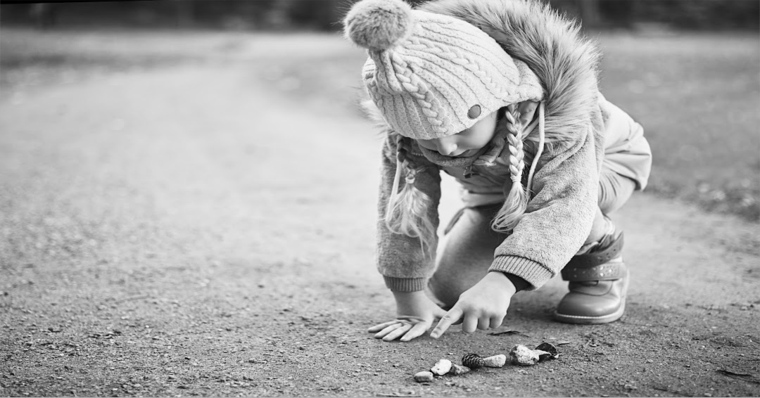 Child picking up stone