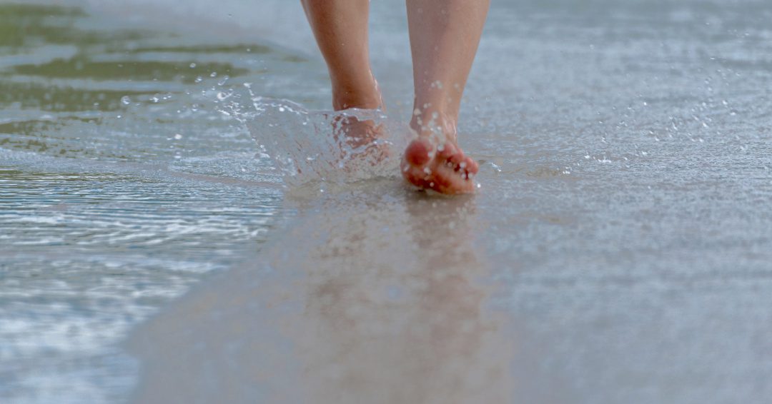 Person Walking in Sand with toes up.