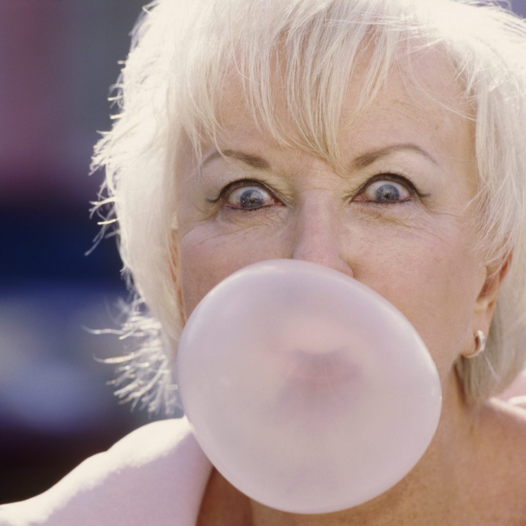 Woman blowing a bubble gum bubble